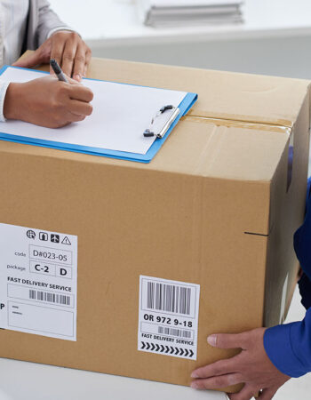 Close-up image of business woman signing document after receiving big box